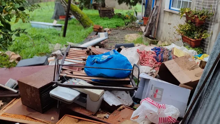 Household belongings and broken furniture scattered outside after the tornado