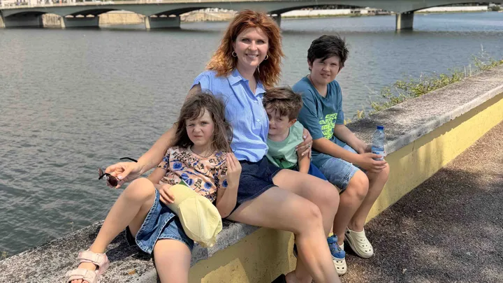 Jenny sitting beside the water with Liam, Olivia, and Bryan before the tornado